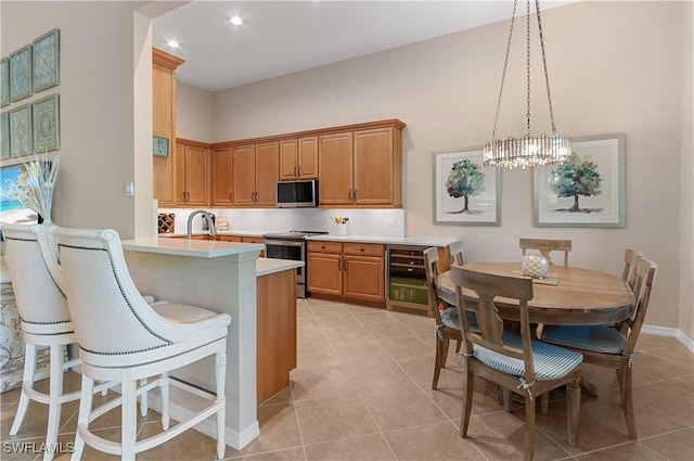 kitchen featuring decorative light fixtures, wine cooler, light tile patterned floors, stainless steel appliances, and an inviting chandelier