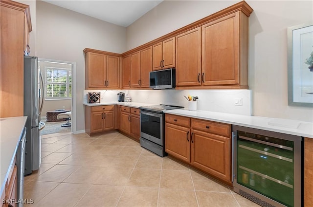 kitchen with wine cooler, tasteful backsplash, light tile patterned flooring, and appliances with stainless steel finishes