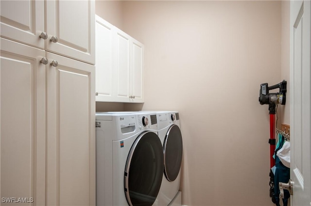 washroom featuring cabinets and washer and dryer