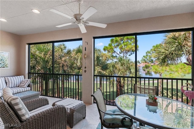 sunroom with a water view, ceiling fan, and plenty of natural light