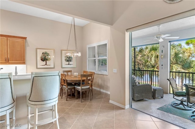 dining space with ceiling fan with notable chandelier and light tile patterned floors