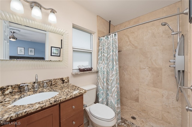 bathroom featuring a shower with curtain, ceiling fan, vanity, and toilet