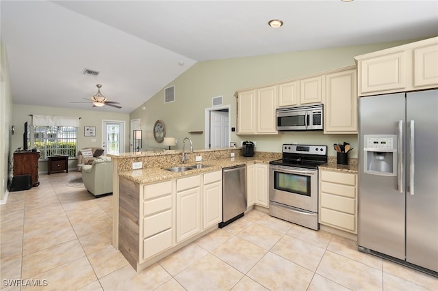 kitchen featuring kitchen peninsula, sink, appliances with stainless steel finishes, and vaulted ceiling