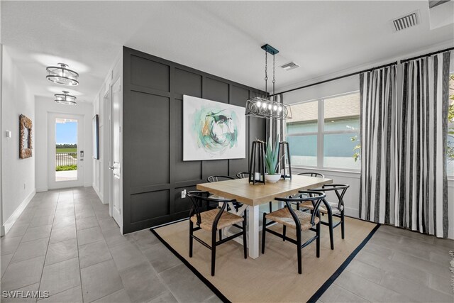 dining area with light tile patterned floors and a chandelier