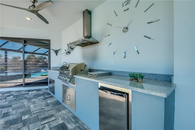 view of patio featuring grilling area, ceiling fan, and an outdoor kitchen