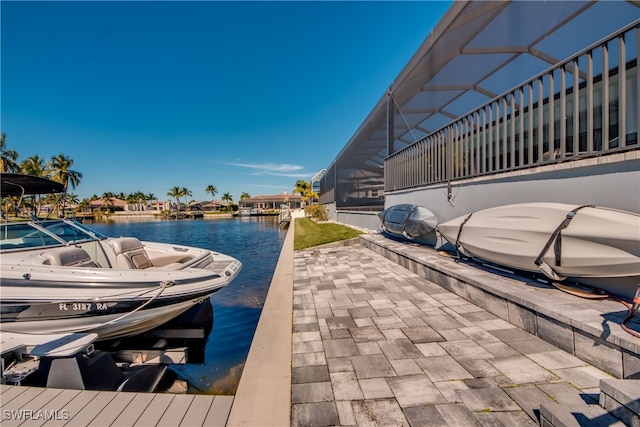 dock area with a lanai and a water view