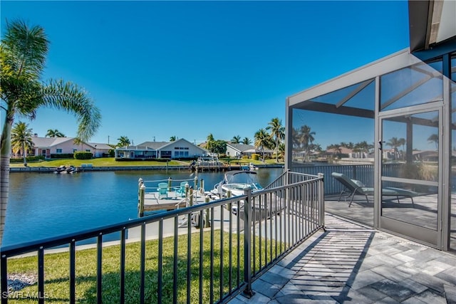 balcony with a residential view, a water view, and a dock