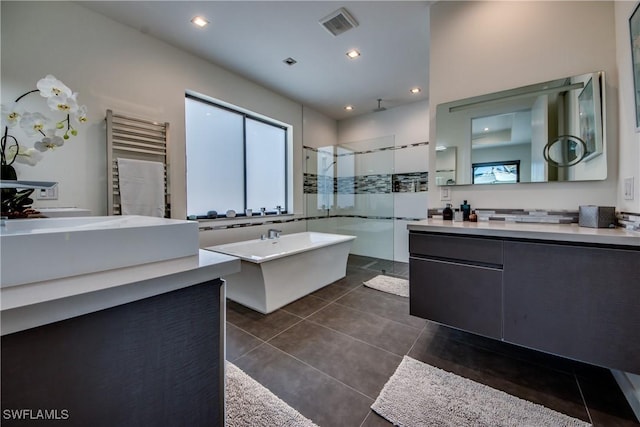 bathroom featuring visible vents, radiator, tile patterned flooring, a shower stall, and two vanities