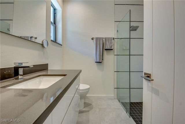 bathroom featuring baseboards, toilet, tile patterned flooring, walk in shower, and vanity