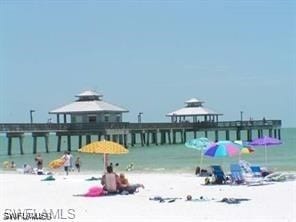 view of property's community with a gazebo, a water view, and a view of the beach