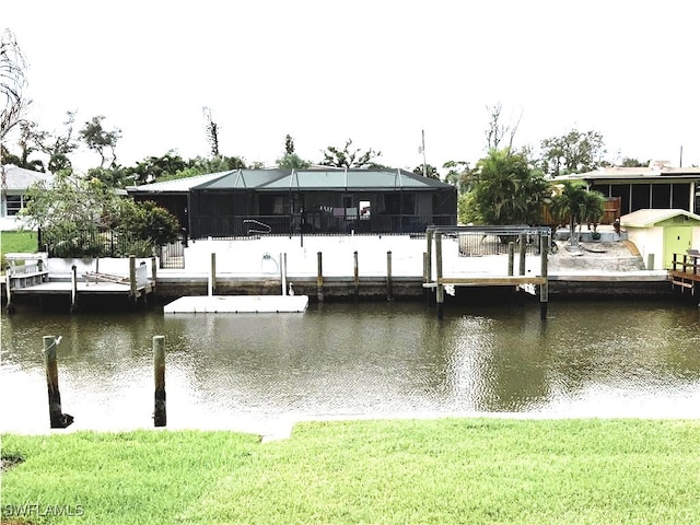 dock area with a lanai, a lawn, and a water view