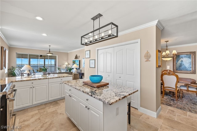 kitchen with ornamental molding, high end stainless steel range oven, a kitchen island, pendant lighting, and white cabinetry