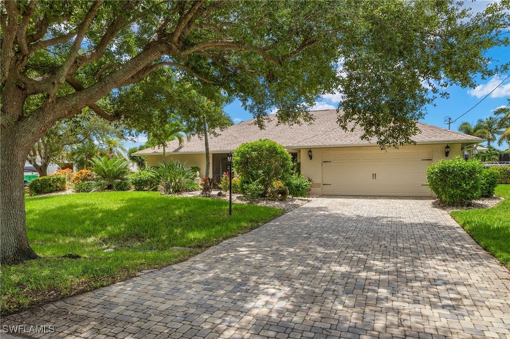 ranch-style home with a garage and a front lawn