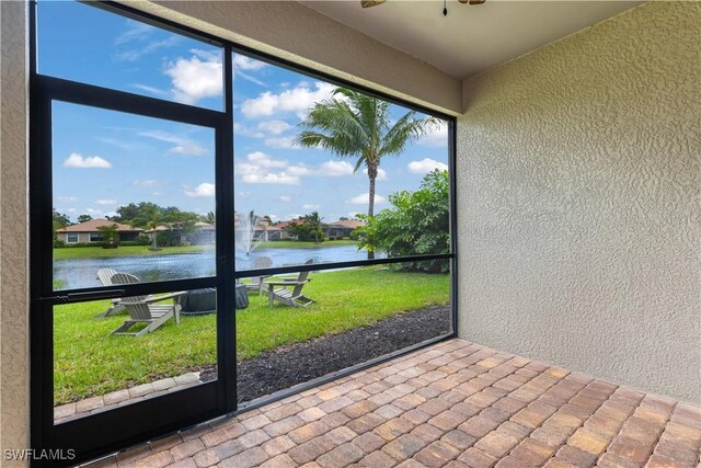 unfurnished sunroom with a water view and ceiling fan