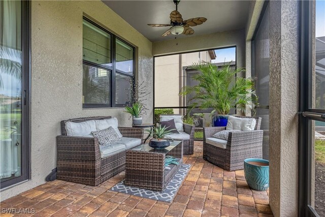 sunroom / solarium featuring ceiling fan