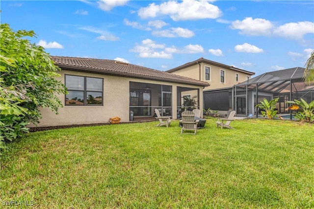 rear view of property featuring glass enclosure, a tile roof, a lawn, and stucco siding