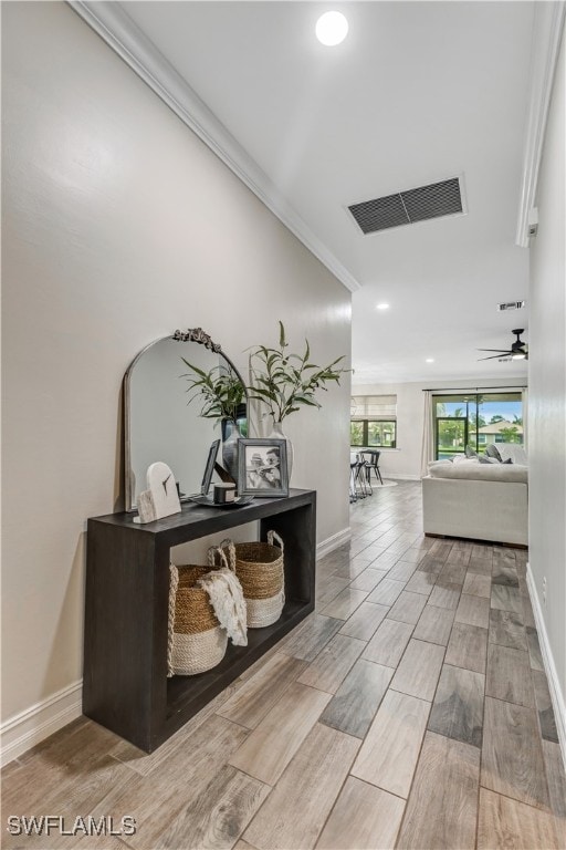 hallway featuring wood finish floors, visible vents, ornamental molding, recessed lighting, and baseboards