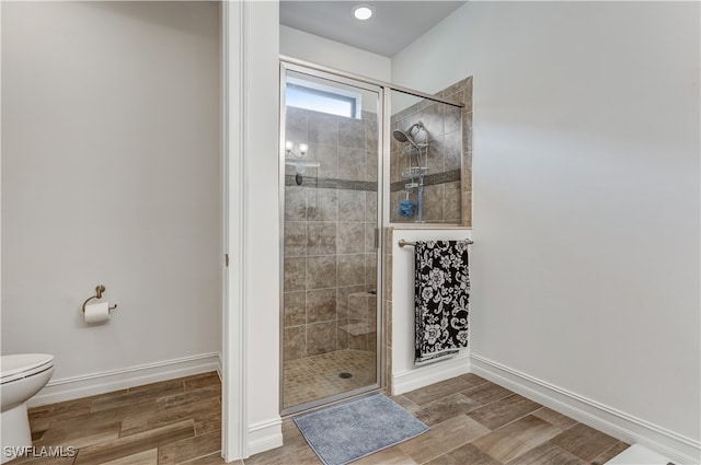 full bath with toilet, a stall shower, and wood finish floors