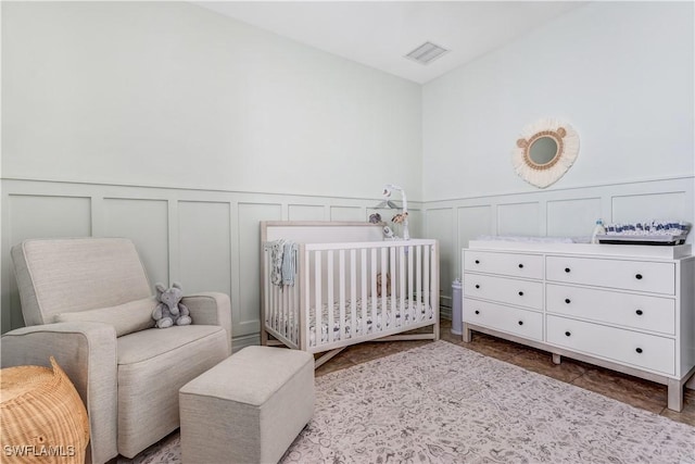 bedroom featuring a crib and visible vents