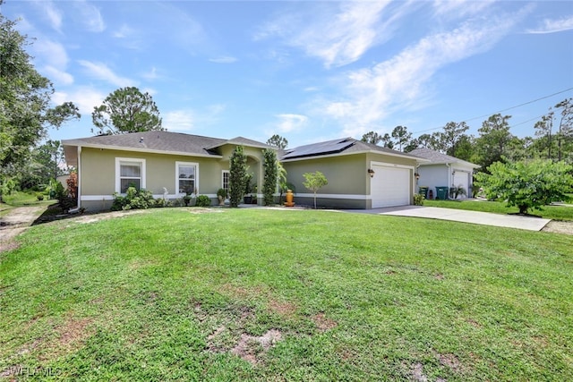 view of front of house with concrete driveway, a front yard, roof mounted solar panels, stucco siding, and an attached garage