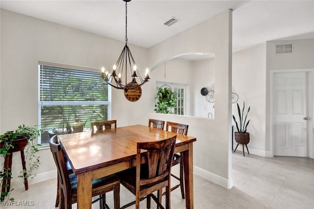 dining area with light tile patterned floors, visible vents, baseboards, and an inviting chandelier