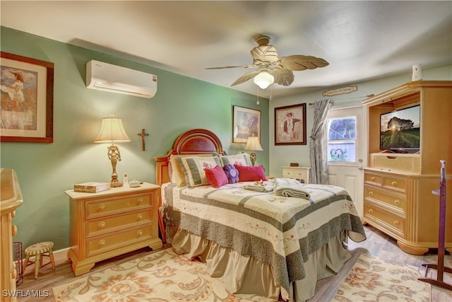 bedroom with a wall mounted air conditioner, ceiling fan, and light hardwood / wood-style flooring