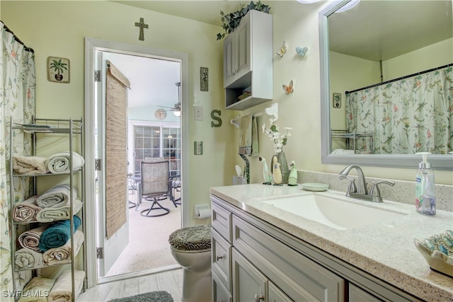 bathroom with curtained shower, vanity, and toilet