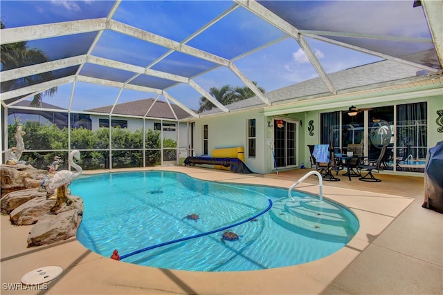 view of pool with ceiling fan, a lanai, and a patio