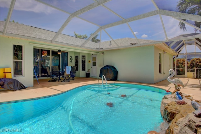 view of swimming pool featuring glass enclosure and a patio area