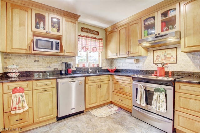 kitchen with decorative backsplash, stainless steel appliances, and dark stone counters