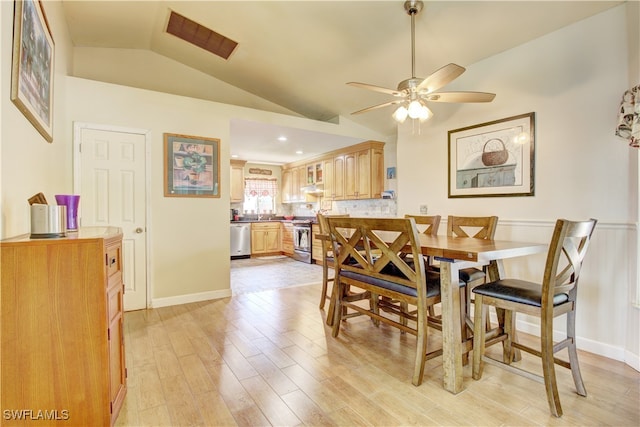 dining space featuring ceiling fan, lofted ceiling, and light wood-type flooring