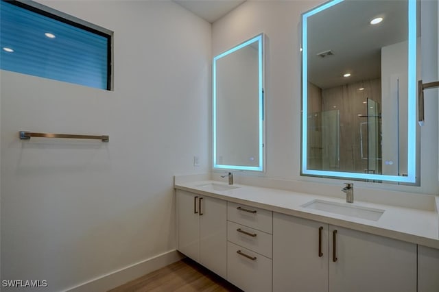 bathroom with hardwood / wood-style floors, vanity, and walk in shower