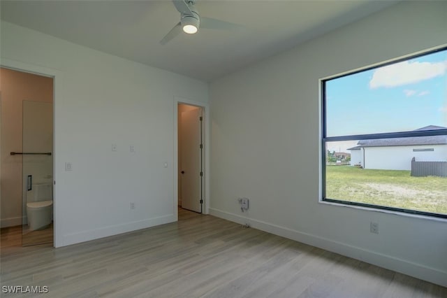 unfurnished bedroom featuring ceiling fan, light hardwood / wood-style floors, and connected bathroom