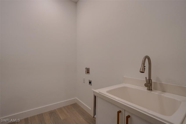 laundry room with washer hookup, electric dryer hookup, light hardwood / wood-style floors, and sink