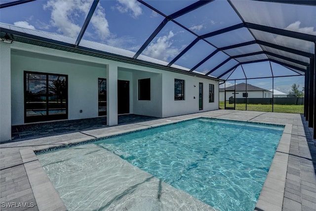 view of pool featuring glass enclosure and a patio area