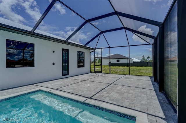 view of swimming pool featuring a lawn, glass enclosure, and a patio area