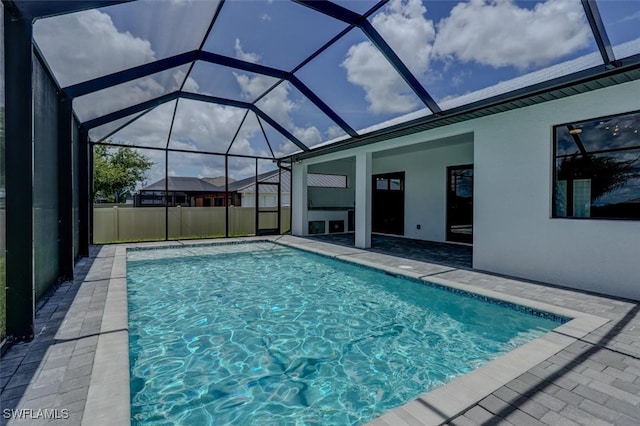 view of pool featuring glass enclosure and a patio area