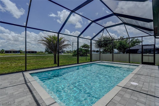 view of swimming pool with a lawn, glass enclosure, and a patio