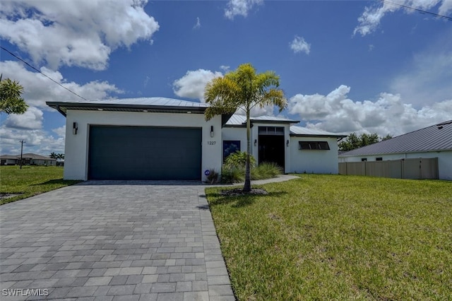 view of front of property with a garage and a front lawn