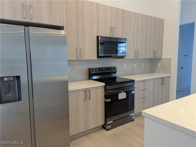 kitchen featuring black range with electric stovetop, stainless steel fridge with ice dispenser, light brown cabinets, and decorative backsplash