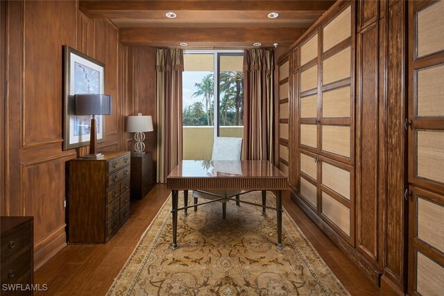 home office featuring beamed ceiling, wooden walls, and dark hardwood / wood-style floors