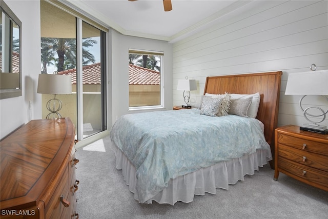 carpeted bedroom featuring crown molding, access to exterior, and ceiling fan