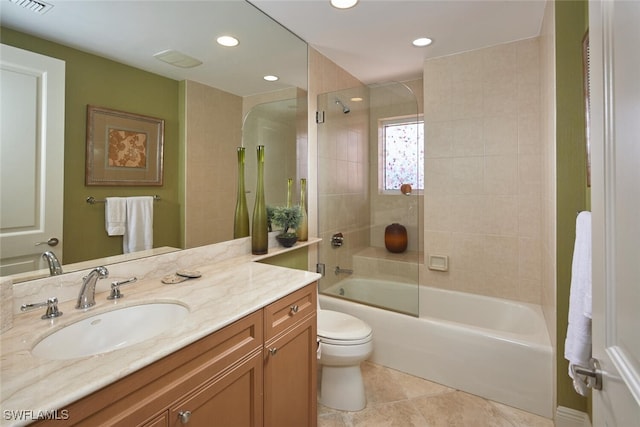 full bathroom featuring tiled shower / bath, vanity, toilet, and tile patterned floors