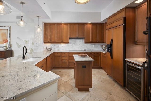 kitchen featuring pendant lighting, sink, wine cooler, light stone counters, and paneled fridge