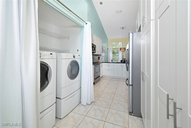 laundry area with light tile patterned flooring and washer and dryer