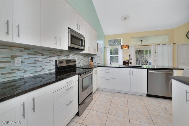 kitchen featuring tasteful backsplash, stainless steel appliances, white cabinets, sink, and light tile patterned floors