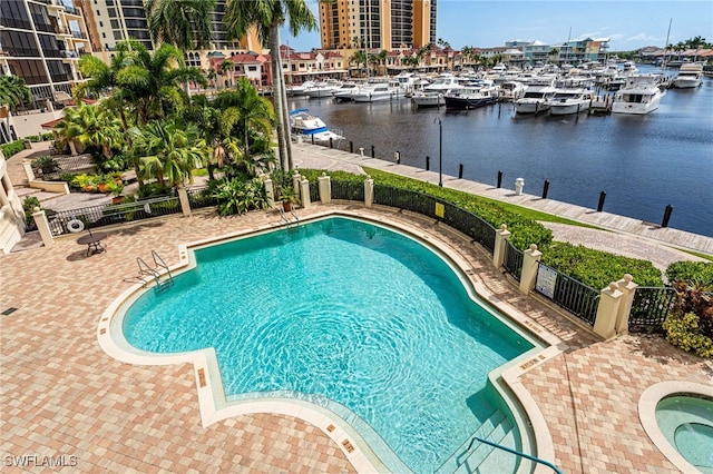 view of pool with a water view and a patio area