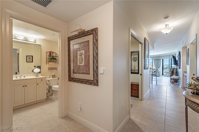 hall with sink and light tile patterned floors