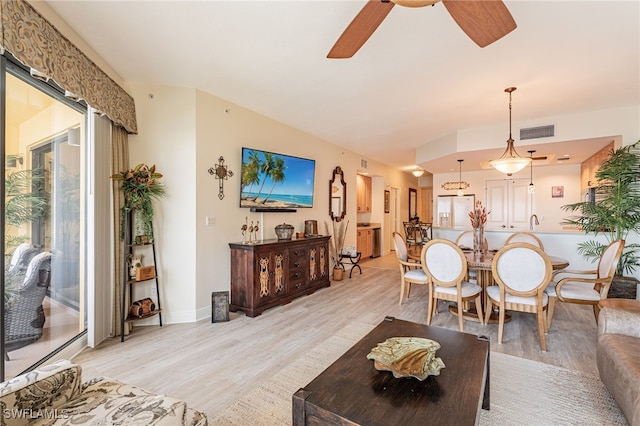 living room featuring sink, ceiling fan, and light hardwood / wood-style flooring