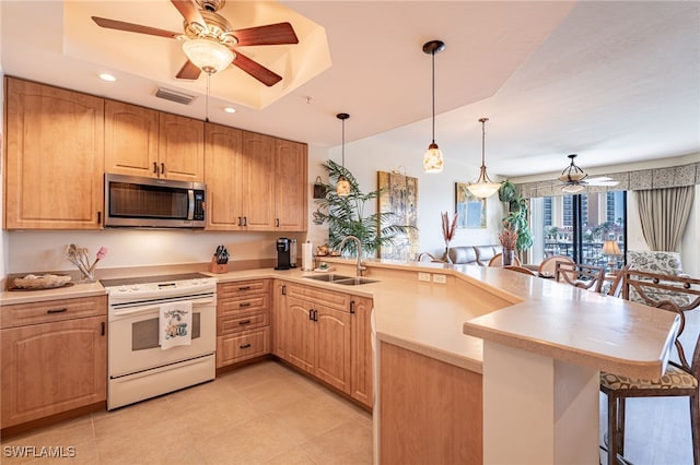 kitchen featuring sink, a kitchen breakfast bar, decorative light fixtures, white electric stove, and kitchen peninsula